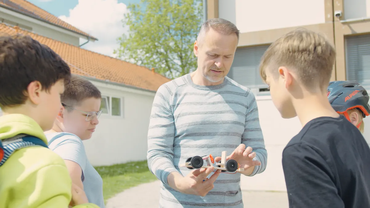 Berufsorientierung im Startchancen-Programm - Lehrer erklärt Schülern Modellauto